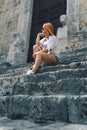 A cute girl sitting on the steps. Narni Terni, Umbria, Italy, medieval city: a typical old street. Vertical photo Royalty Free Stock Photo