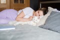 Cute girl sleeping on a bed next to a white cat