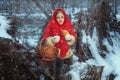 Cute girl stands in the winter forest and eats a pie Royalty Free Stock Photo