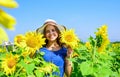 Cute girl in straw hat walking sunflowers farm, healthy life