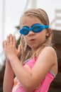 Cute girl in swimming glasses and swimsuit, going to dive into the water Royalty Free Stock Photo