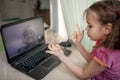 Cute girl talking with her grandmother within video chat on laptop, life in quarantine time Royalty Free Stock Photo