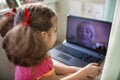 Cute girl talking with her grandmother within video chat on laptop, life in quarantine time Royalty Free Stock Photo