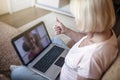 Cute girl talking with her grandmother within video chat on laptop, life in quarantine time Royalty Free Stock Photo