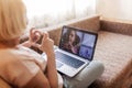 Cute girl talking with her grandmother within video chat on laptop, life in quarantine time Royalty Free Stock Photo