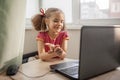 Cute girl talking with her grandmother within video chat on laptop, life in quarantine time Royalty Free Stock Photo