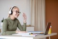 Cute girl teenager waving at laptop screen