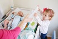 Cute girl toddler helping her mother, changing baby diaper Royalty Free Stock Photo