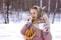 Cute girl in a traditional Russian headscarf with mug of hot tea and bagels on winter background. Royalty Free Stock Photo