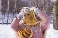 Cute girl in a traditional Russian headscarf with pancake and bagels on winter background. Royalty Free Stock Photo