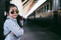 Cute girl in train station waiting to travel. Summer holiday.