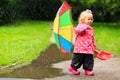 Cute girl with umbrella in raincoat and boots outdoor Royalty Free Stock Photo