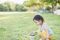 Cute girl using magnifying glass to look at bugs in glass jars Learn to use science-related observations Royalty Free Stock Photo