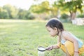 Cute girl using magnifying glass to look at bugs in glass jars Learn to use science-related observations Royalty Free Stock Photo