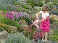 Cute girl watering flower in the garden Royalty Free Stock Photo