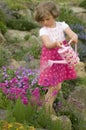 Cute girl watering flower in the garden Royalty Free Stock Photo