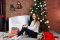 Cute girl wear on warm sweaters, black pants against new year tree with christmas decoration at studio