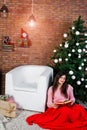 Cute girl wear on warm sweaters, black pants against new year tree with christmas decoration at studio