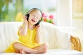 Cute girl wearing huge wireless headphones. Pretty child listening to the music. Schoolgirl having fun listening to kid`s songs at Royalty Free Stock Photo