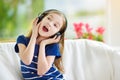 Cute girl wearing huge wireless headphones. Pretty child listening to the music. Schoolgirl having fun listening to kid`s songs at Royalty Free Stock Photo