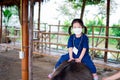 Cute girl wearing white face mask is riding on buffalo back. Learn and experience natural classroom.