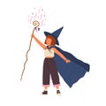 Cute girl wearing witch hat and cloak conjures with magic stick. Young female wizard or sorcerer. Adorable little