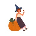 Cute girl wearing witch hat hold lollipop and sit on Halloween pumpkin. Portrait of young sorcerer with red hair. Flat Royalty Free Stock Photo