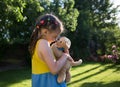 Cute girl of 6-7 years old plays nose to nose with her plush dog