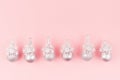 Cute girlish glamour Christmas background - bright silver balls with snowflakes in row as decorative border on pastel pink. Royalty Free Stock Photo