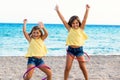 Cute girls dancing with plastic rings on beach. Royalty Free Stock Photo