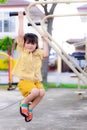 Cute girls exercising in a small playground. Adorable child was hanging on the trapeze happily. Sweet smile.