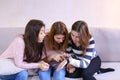 Cute girls looking at and studying stylish iWatch, sitting on co