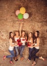 Cute girls posing with presents, balloons and cake