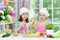Cute girls preparing delicious fresh salad in kitchen