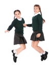 Cute girls in school uniform jumping on white