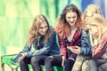 Cute girls sitting on the bench in the park and laughing Royalty Free Stock Photo