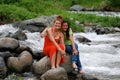 Cute girls sitting by rapids Royalty Free Stock Photo