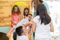 Cute girls smiling during supervised playtime in a modern kindergarten