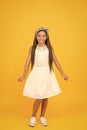 Cute girly girl. Happy girl yellow background. Fashion look of small girl. Little girl wear long brunette hair. Beauty Royalty Free Stock Photo