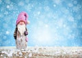 Cute gnome on festive blue background with snow. Christmas or New Year greeting card