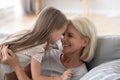 Cute granddaughter having fun playing with grandmother embracing Royalty Free Stock Photo