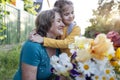 Cute granddaughter hugging her happy grandmother. The hugs of an elderly woman and a little girl against the backdrop of summer Royalty Free Stock Photo