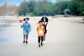 Cute groups of African kids have fun activity together on summer beach blue sea, two girls with black curly hair and boy running Royalty Free Stock Photo