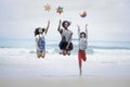 Cute groups of kids have fun on sandy summer beach with blue sea, happy childhood friends  jump together and play on tropical Royalty Free Stock Photo