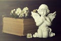 Guardian angel, spring flowers and old book