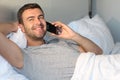 Cute guy comfortably calling in bed Royalty Free Stock Photo