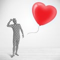 Cute guy in morpsuit body suit looking at a balloon shaped heart