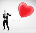 Cute guy in morpsuit body suit looking at a balloon shaped heart