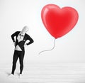 Cute guy in morpsuit body suit looking at a balloon shaped heart