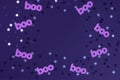 Cute Halloween Layout Border Made of Paper Cut Boo and Shrimmering Silver and Black Confetti of Star Shape on a Violet Background. Royalty Free Stock Photo